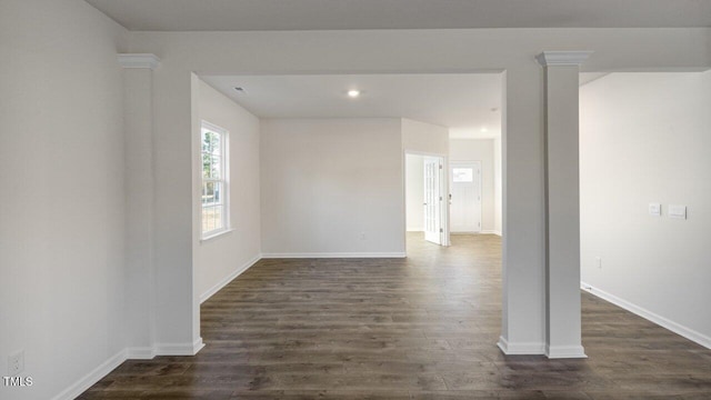 spare room with decorative columns and dark hardwood / wood-style floors