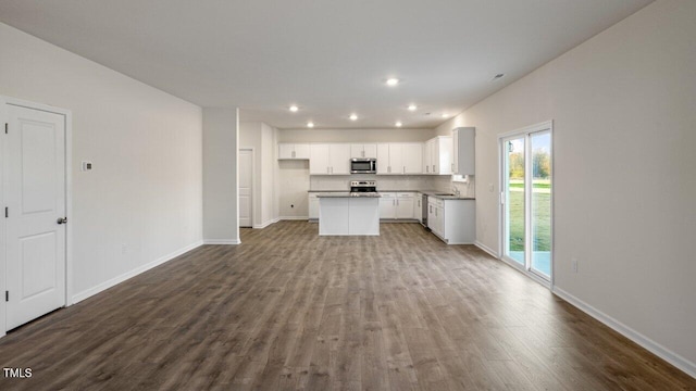 kitchen featuring sink, hardwood / wood-style flooring, appliances with stainless steel finishes, white cabinetry, and a kitchen island