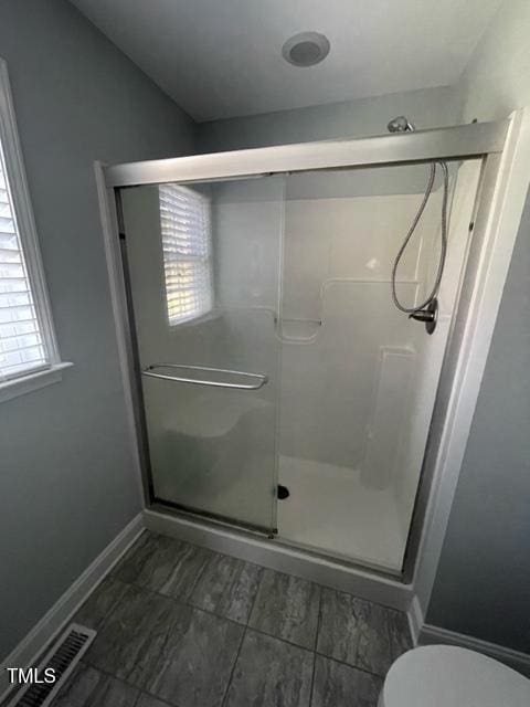 bathroom featuring walk in shower and toilet