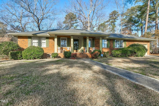 ranch-style house featuring a porch, a garage, and a front lawn