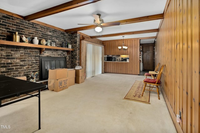 living room featuring brick wall, wood walls, ceiling fan, light carpet, and beam ceiling