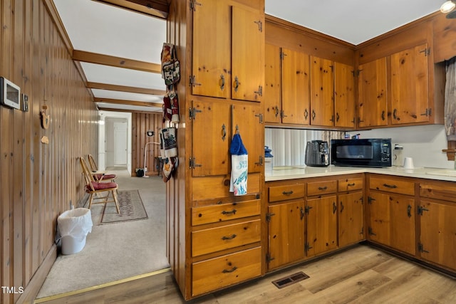 kitchen featuring wood walls and light wood-type flooring