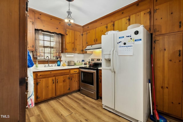 kitchen featuring sink, decorative light fixtures, white fridge with ice dispenser, electric stove, and light hardwood / wood-style floors