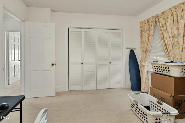 bedroom with light carpet and a closet