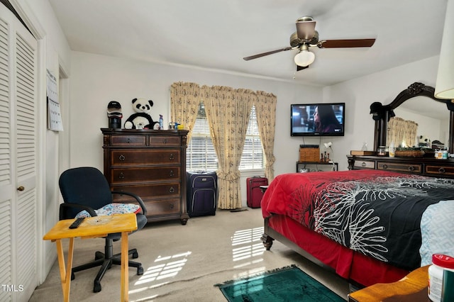 carpeted bedroom featuring ceiling fan and a closet