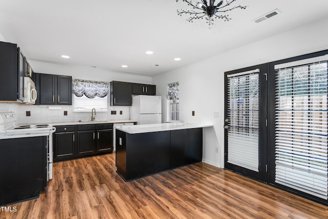 kitchen featuring dark hardwood / wood-style flooring, sink, white appliances, and decorative backsplash