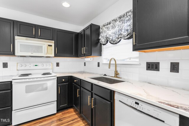 kitchen featuring tasteful backsplash, sink, white appliances, and light wood-type flooring