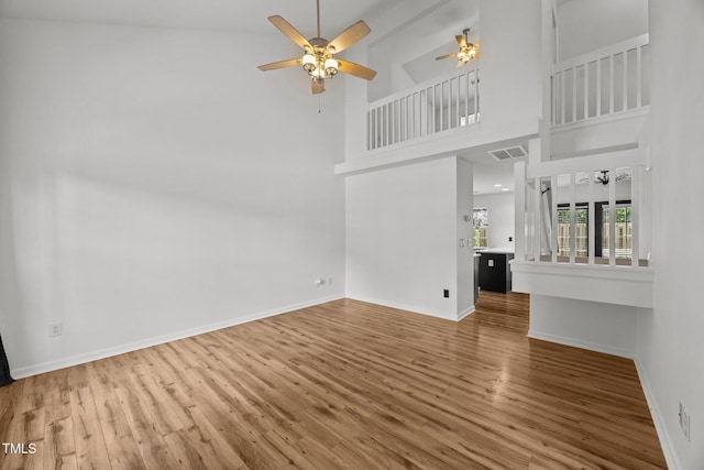 4619 Cross Ridge Ln, Greensboro, NC 27410 - unfurnished living room featuring a ceiling fan, wood finished floors, and a high ceiling