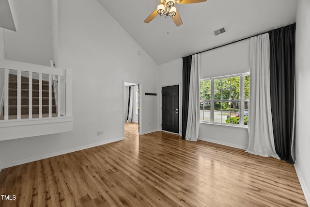 4619 Cross Ridge Ln, Greensboro, NC 27410 - unfurnished living room with a ceiling fan, high vaulted ceiling, wood finished floors, and stairway