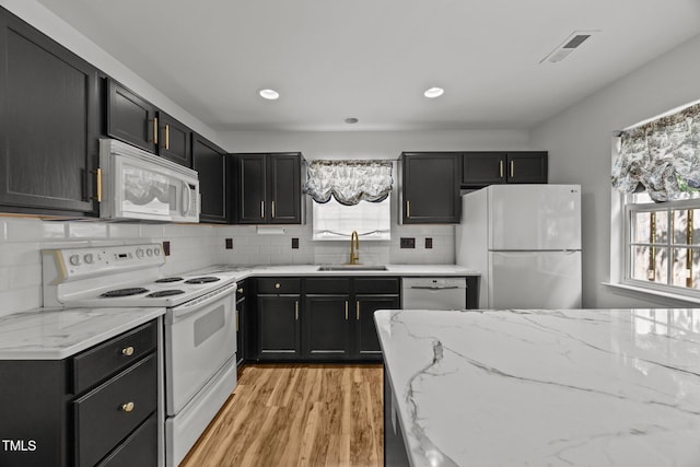 4619 Cross Ridge Ln, Greensboro, NC 27410 - kitchen with white appliances, plenty of natural light, dark cabinets, light wood-style flooring, and recessed lighting