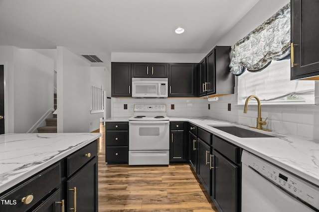 4619 Cross Ridge Ln, Greensboro, NC 27410 - kitchen featuring white appliances, light wood-type flooring, tasteful backsplash, and dark cabinets