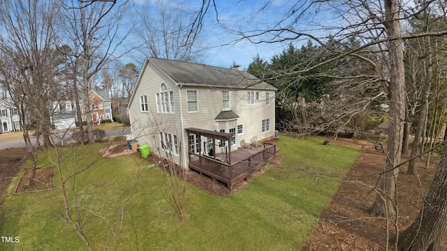 rear view of house featuring a yard and a deck