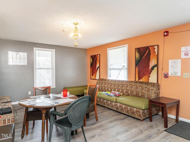 dining space featuring light hardwood / wood-style floors and a textured ceiling