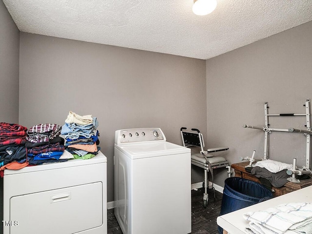 laundry room with dark wood-type flooring, washer and dryer, and a textured ceiling