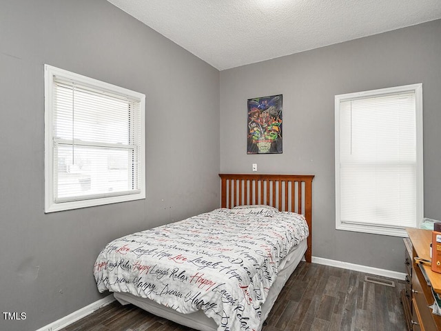 bedroom featuring dark hardwood / wood-style floors and a textured ceiling