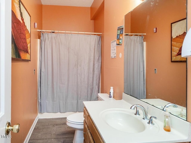 full bathroom with hardwood / wood-style flooring, vanity, shower / bath combo, and toilet