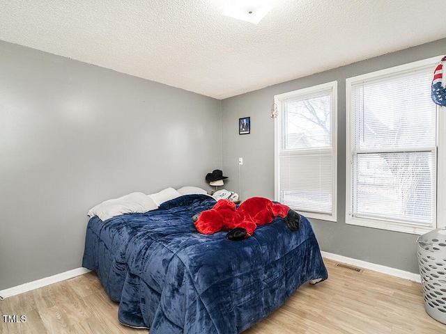 bedroom with hardwood / wood-style flooring and a textured ceiling