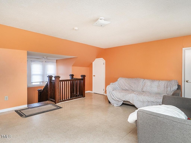 living area with vaulted ceiling and a textured ceiling