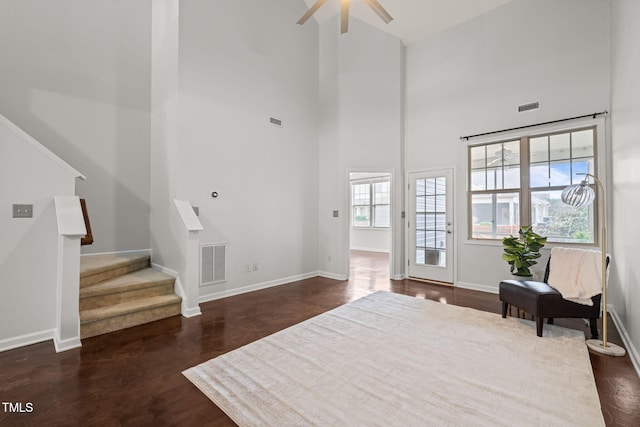 living area featuring ceiling fan and a high ceiling