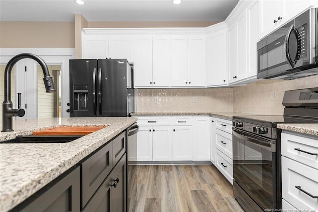 kitchen featuring black appliances, a sink, white cabinets, tasteful backsplash, and recessed lighting