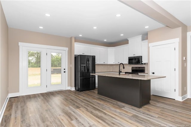 kitchen with black appliances, a sink, white cabinetry, wood finished floors, and recessed lighting