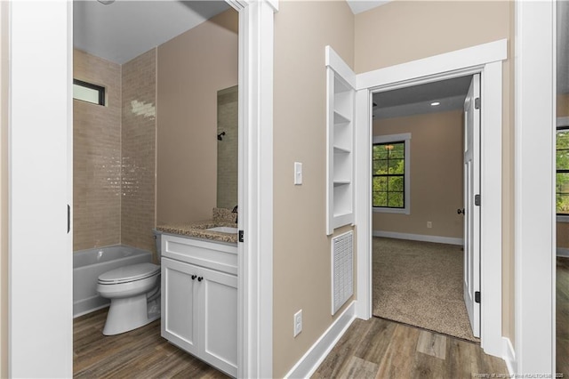 bathroom featuring wood finished floors, vanity, toilet, and baseboards
