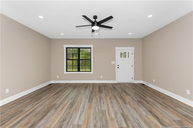 unfurnished living room with wood finished floors, baseboards, a ceiling fan, and recessed lighting