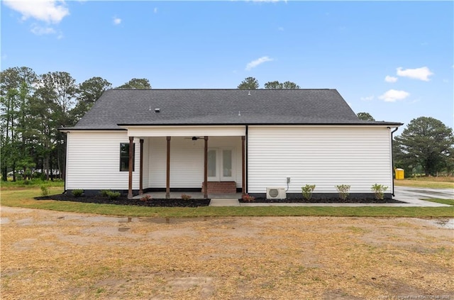 back of house with roof with shingles