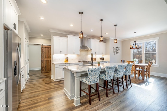 kitchen featuring white cabinetry, a barn door, pendant lighting, and stainless steel fridge