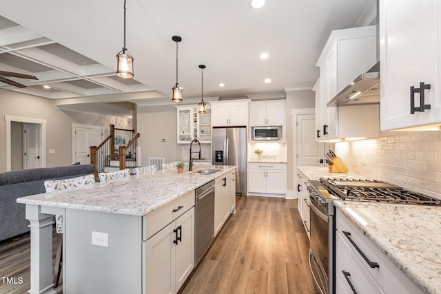 kitchen with stainless steel appliances, a center island with sink, and white cabinets