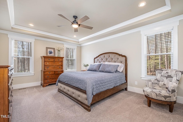 carpeted bedroom featuring ornamental molding, ceiling fan, and a tray ceiling