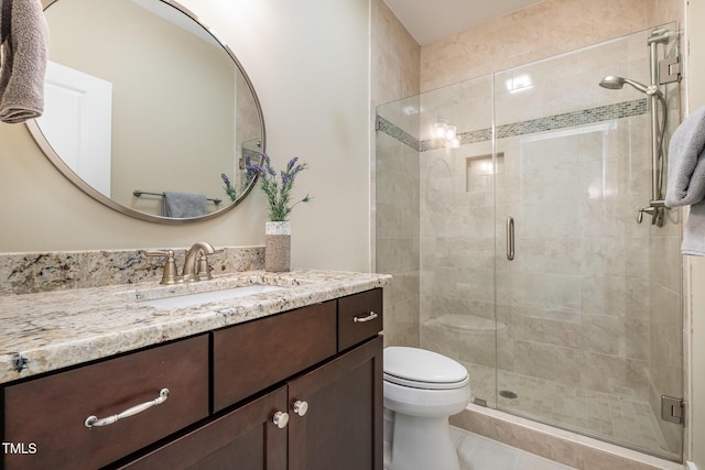 bathroom with vanity, a shower with shower door, and toilet