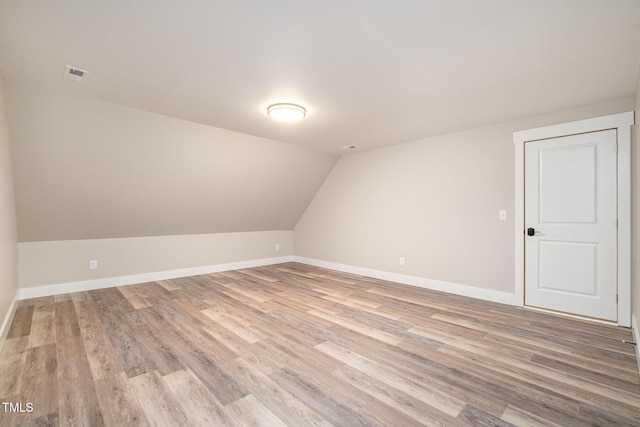 bonus room with lofted ceiling and light hardwood / wood-style flooring