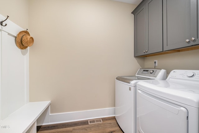 laundry room with cabinets, dark wood-type flooring, and independent washer and dryer