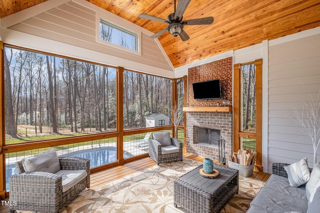 sunroom / solarium featuring an outdoor brick fireplace, ceiling fan, lofted ceiling, and wood ceiling