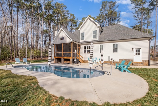 rear view of property featuring a yard, a patio area, and a sunroom