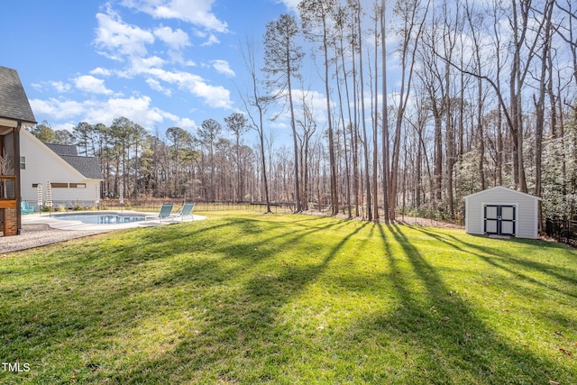 view of yard featuring a fenced in pool and a storage shed