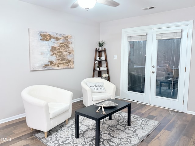 sitting room featuring dark wood-type flooring, french doors, and ceiling fan