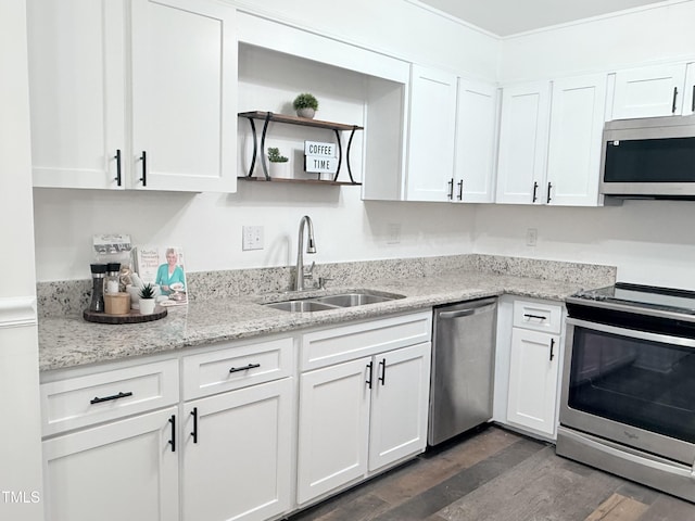 kitchen with sink, appliances with stainless steel finishes, light stone countertops, white cabinets, and dark hardwood / wood-style flooring