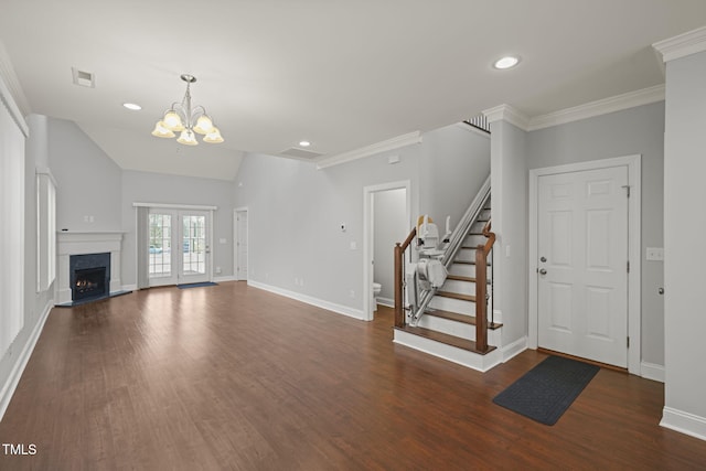 unfurnished living room featuring dark hardwood / wood-style floors, lofted ceiling, a chandelier, crown molding, and french doors