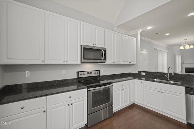 kitchen with white cabinetry, sink, ornamental molding, stainless steel appliances, and dark wood-type flooring