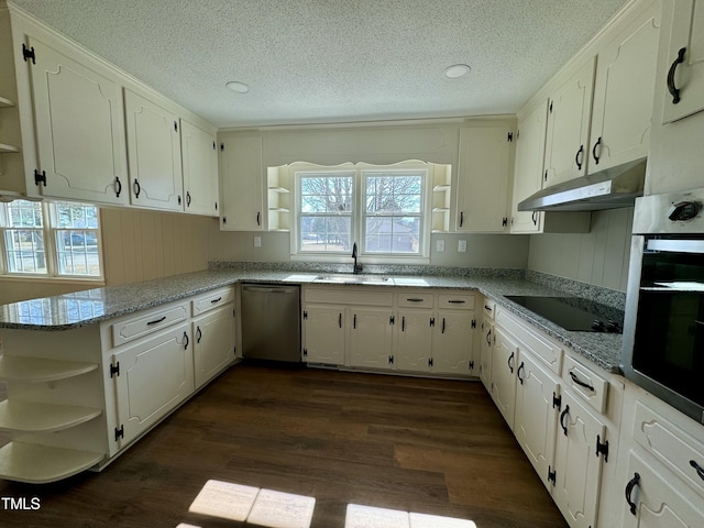 kitchen with light stone counters, stainless steel appliances, kitchen peninsula, and white cabinets