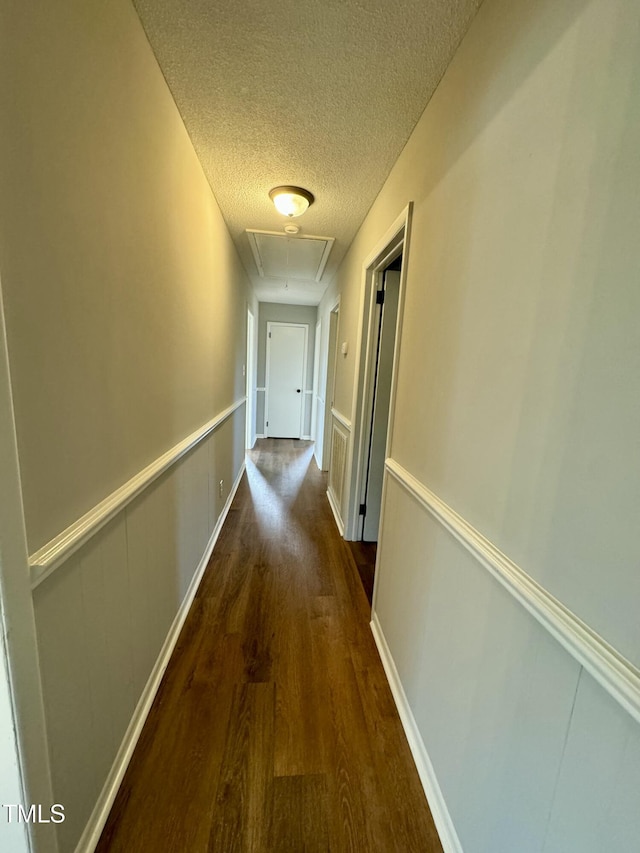 hall featuring dark hardwood / wood-style floors and a textured ceiling