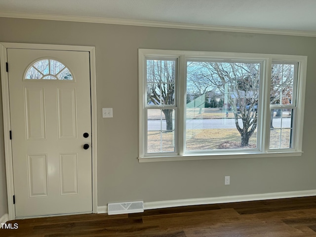 entrance foyer with ornamental molding and dark hardwood / wood-style floors