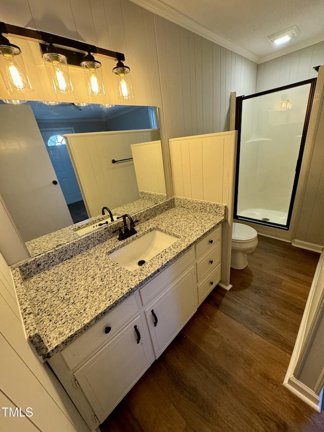 bathroom featuring crown molding, hardwood / wood-style flooring, an enclosed shower, vanity, and toilet