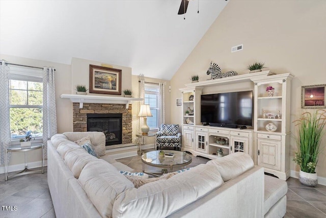 living room featuring a fireplace, a wealth of natural light, high vaulted ceiling, and ceiling fan