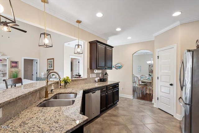 kitchen with light stone counters, sink, stainless steel appliances, and dark brown cabinetry