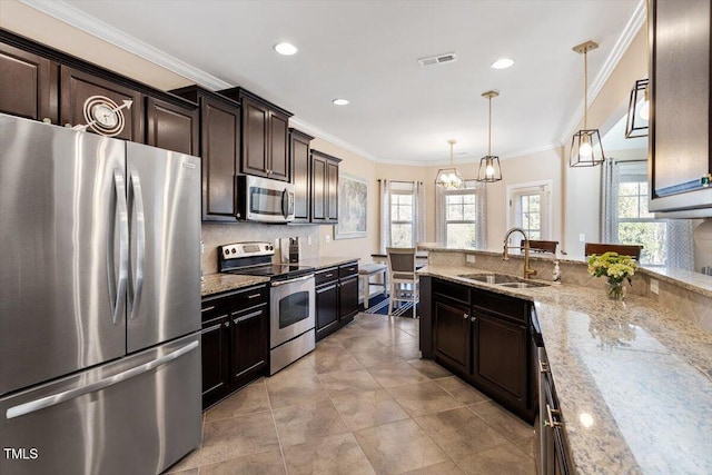 kitchen with appliances with stainless steel finishes, sink, pendant lighting, and dark brown cabinetry