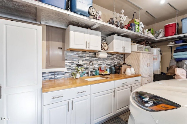 kitchen with white cabinetry, electric water heater, sink, and wooden counters