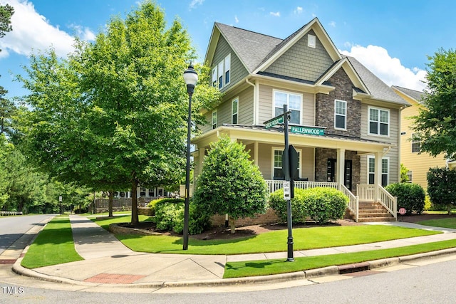 view of front of home featuring covered porch and a front lawn